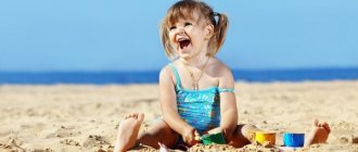 Девочка сидит на песке пляже