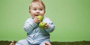 Ребенок держит в руках яблоки