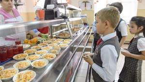 Ученики начальной школы выбирают еду в столовой